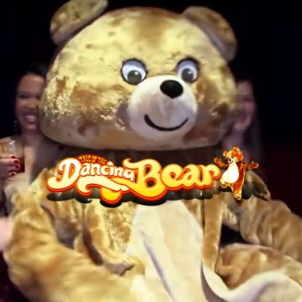 Women laughing and having fun at The Dancing Bear nightclub during the $1 trial night, with a dancing bear mascot entertaining guests.